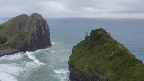 drone flying over high green rocky cliffs in ocean, wild coast transkei