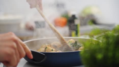 crop person stirring vegetable stew with mushrooms