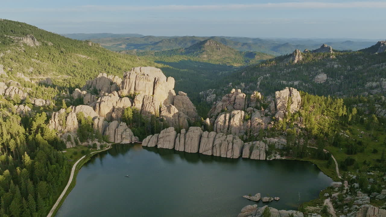 Drone footage capturing a wind farm at sunrise, as golden light illuminates the spinning turbines.