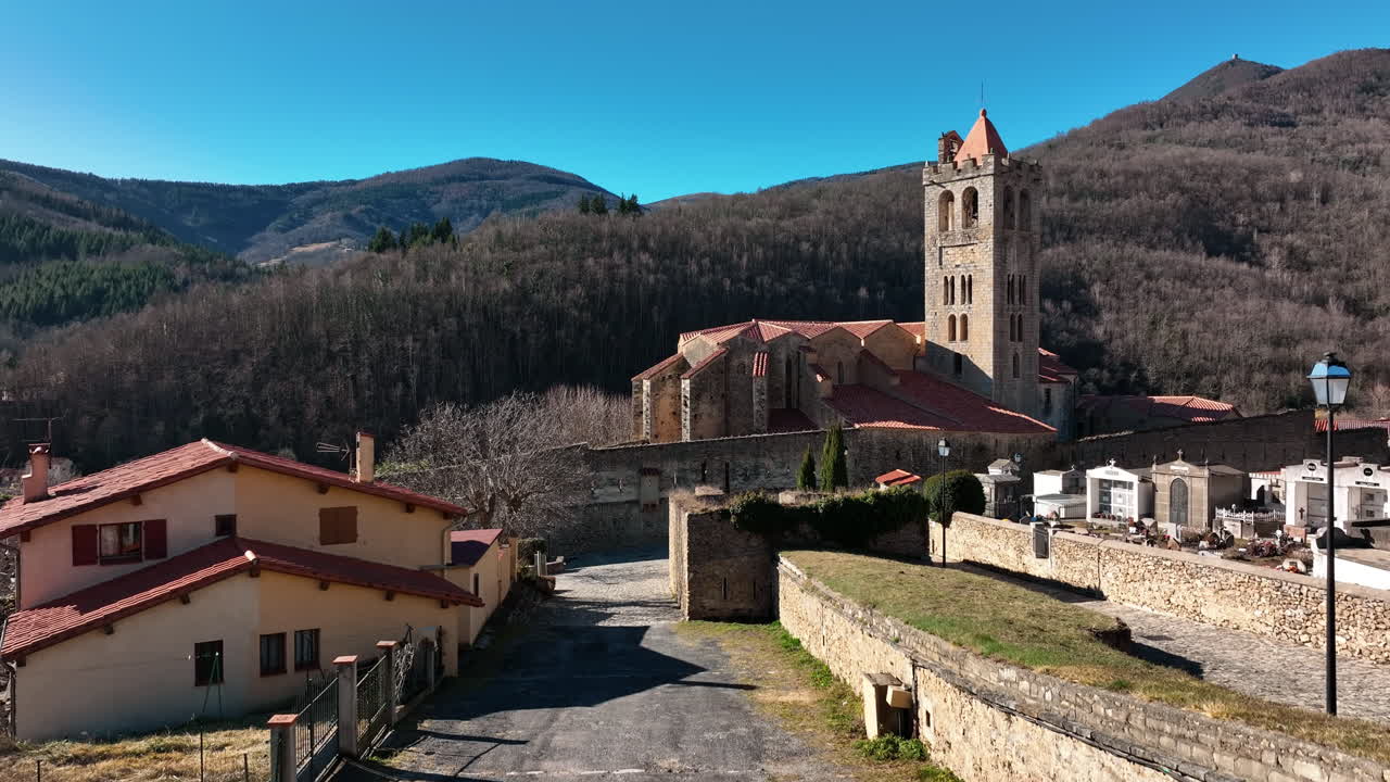 una imagen aérea de un pueblo pirenaico con una torre central de la iglesia.