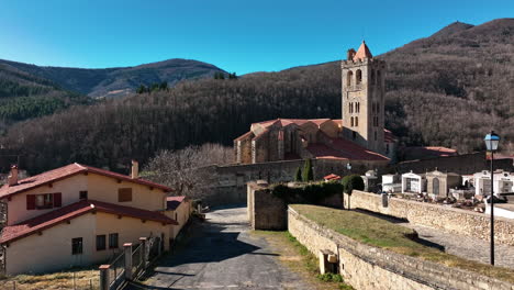 aerial of a pyrenean village with a central church tower.