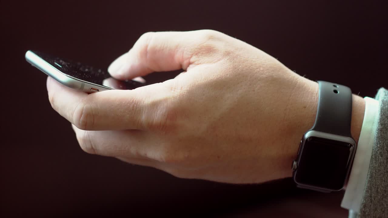 hombre usando teléfono inteligente y reloj inteligente