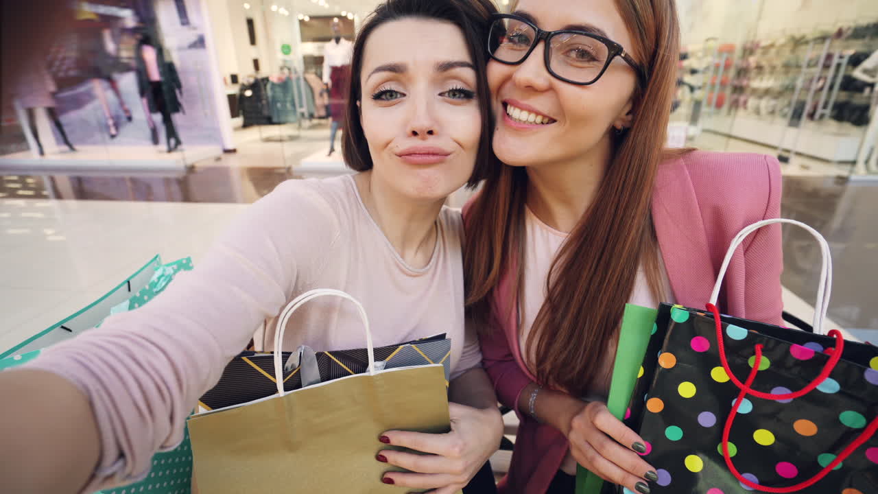 Two happy women shopping in a mall