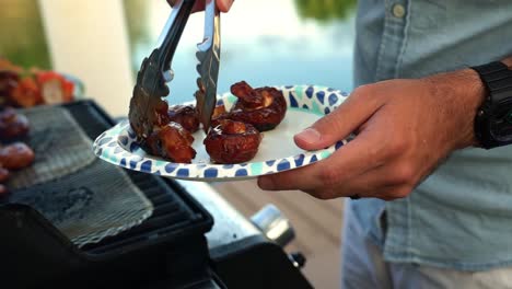 hands plating grilled mushrooms from backyard grill with water canal in background