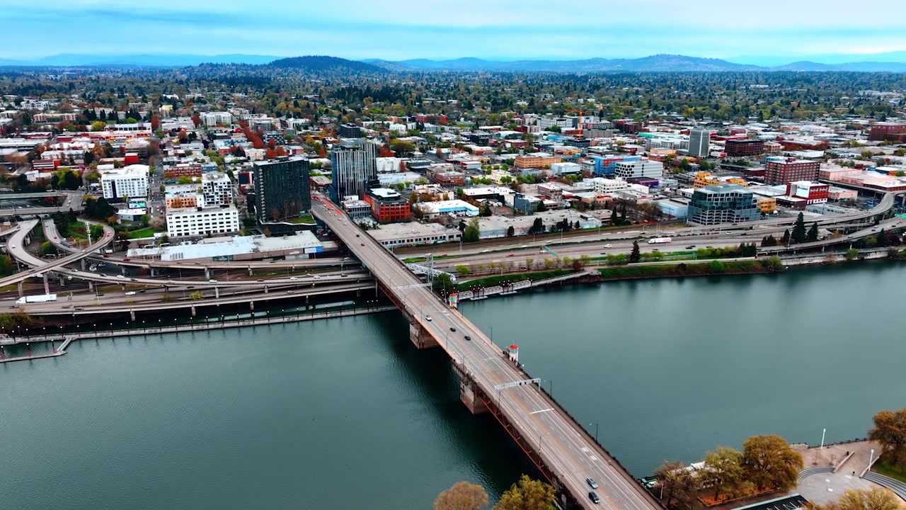Volando sopra il ponte sul fiume Willamette a Portland, Oregon, USA. Bellissimo e vasto paesaggio urbano con molto verde, visto dall'alto.