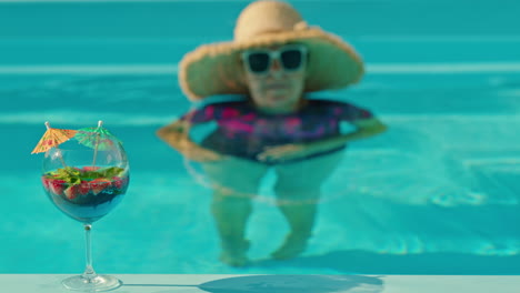 mujer disfrutando de un cóctel junto a la piscina