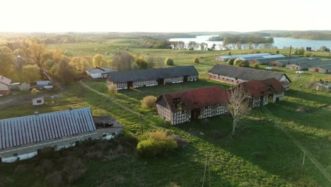 a destroyed complex of outbuildings with a large lake in the background