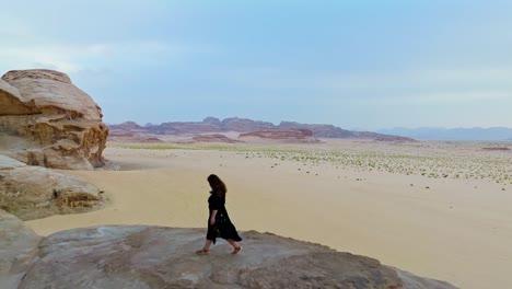 girl traveler walking at kharaza arch in wadi rum desert, aqaba, jordan