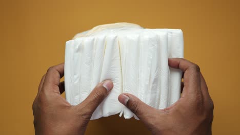 hands holding a stack of baby diapers