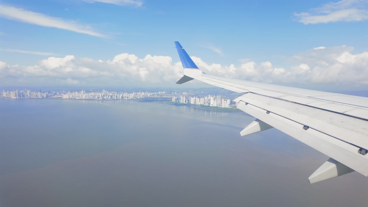 Panama City skyscrapers visible across Panama Bay from plane window during approach, Panama City, Panama, Central America