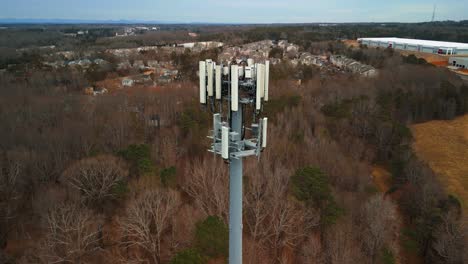 aerial shot flying toward cell phone tower in forest