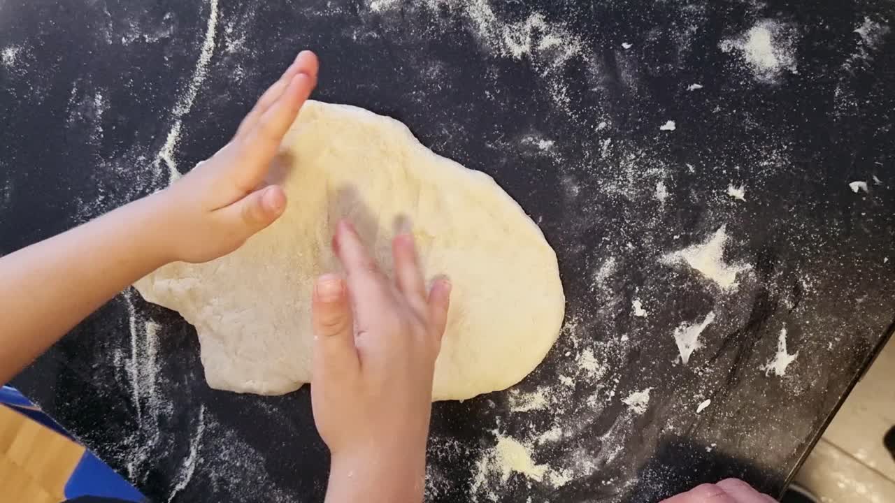 мальчик, растягивающий тесто для пиццы рукой