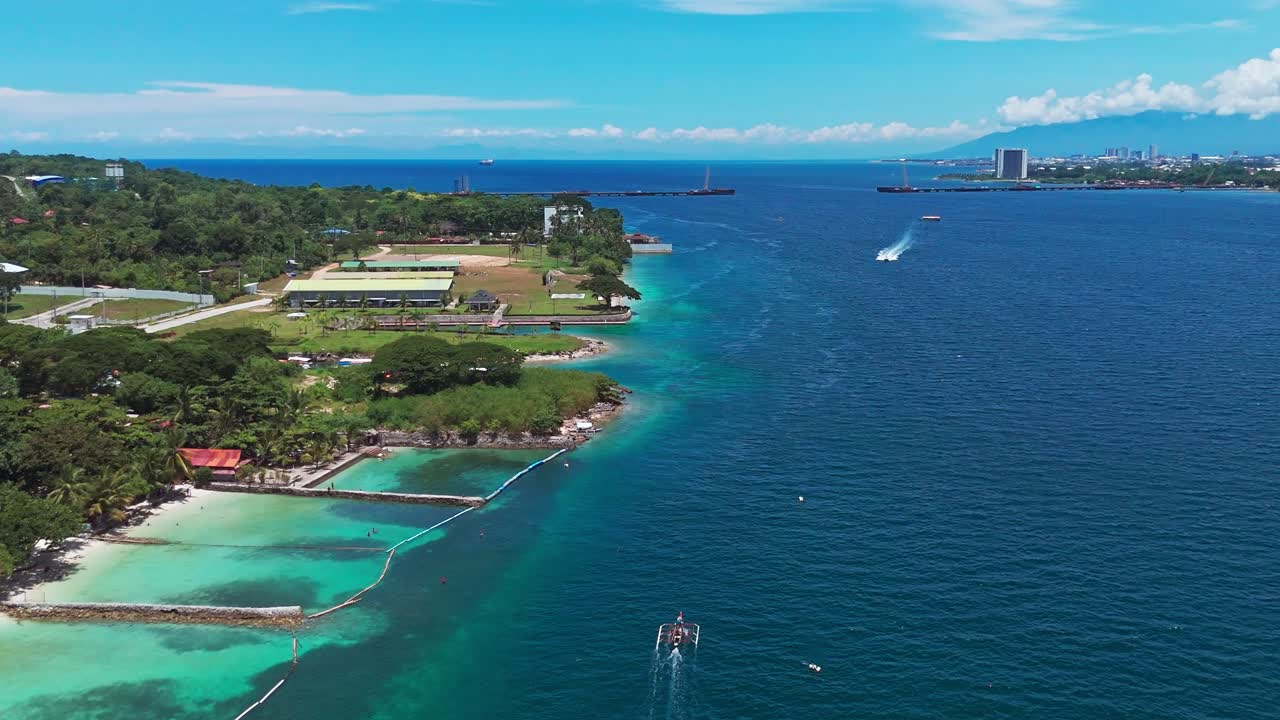 Stunning drone footage of turquoise waters, tropical coastline, and city skyline in the Philippines. Perfect for travel, tourism, and cinematic projects