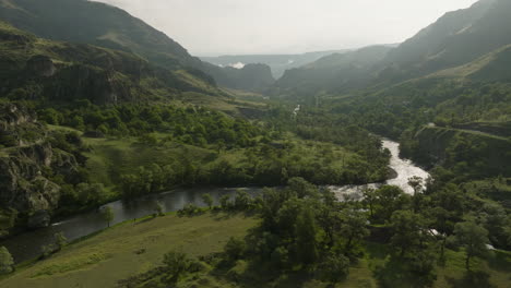 Aerial-View-Of-Mtkvari-River-And-Lush-Green-Mountain-Landscape-With-Mist-In-Georgia