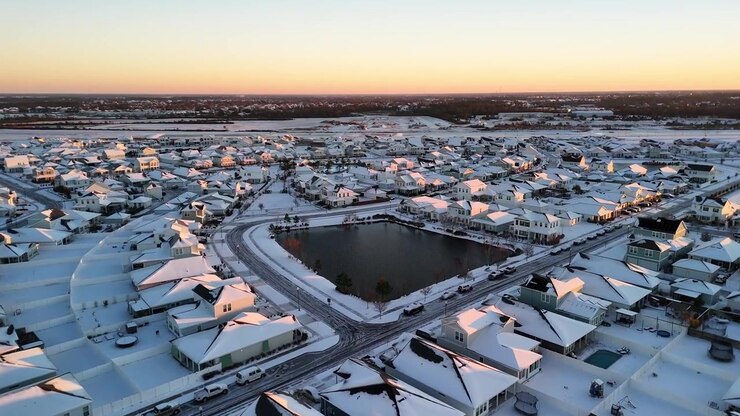 Neighborhood in Florida covered in snow for the first time, sunset drone shot