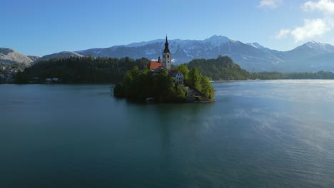 el movimiento de la grúa hacia arriba por encima del edificio de la iglesia revela un panorama de los macizos alpinos alrededor del lago