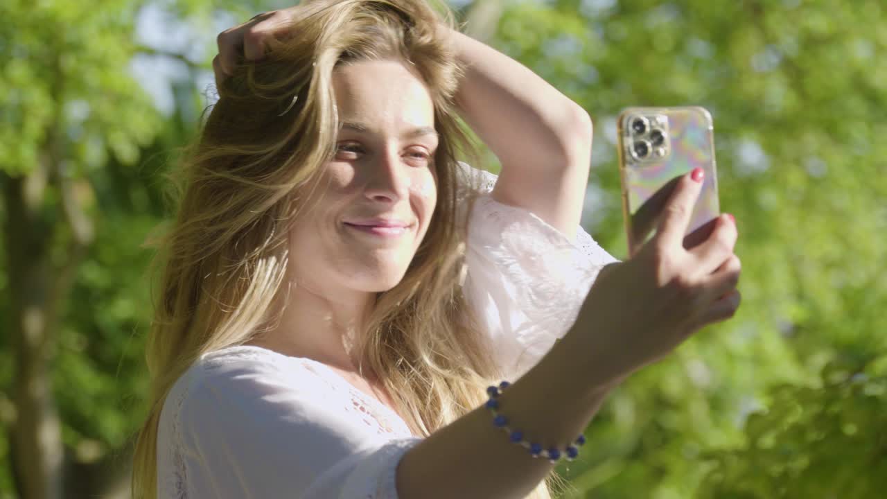 Una hermosa mujer con cabello rubio largo tomándose selfies, posando, haciendo muecas