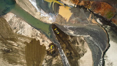 Aerial view of an excavator and a bulldozer moving the sediment of a river