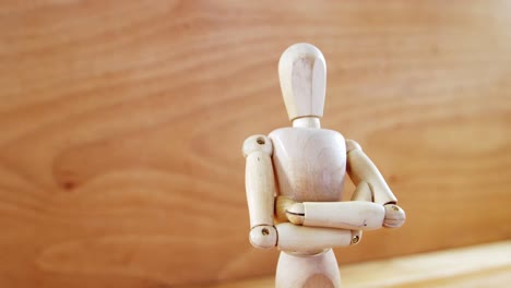 figurine standing with arms crossed on a wooden floor