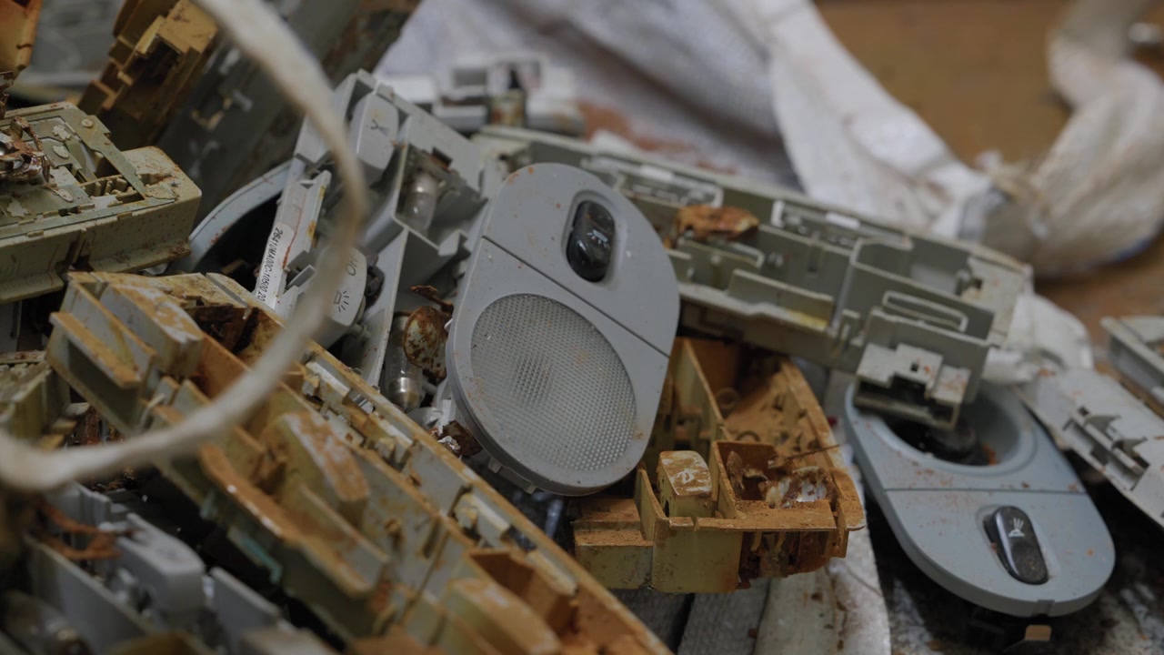 Geri dönüşüm tesisinde sökülmüş elektronik hurda yığını, plastik kasalar ve gri bir hoparlör