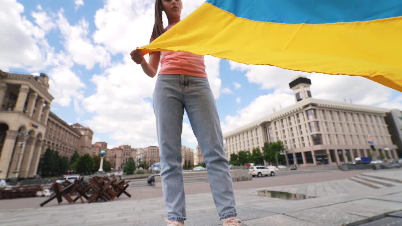 mujer sosteniendo la bandera ucraniana en protesta
