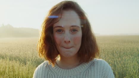 smiling girl in a wheat field at sunrise