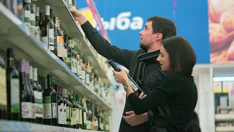 pareja comprando vino en una tienda de comestibles