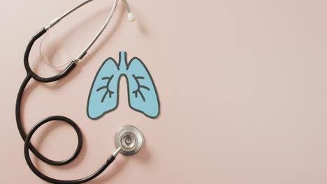 video of close up of stethoscope with lungs on pink background