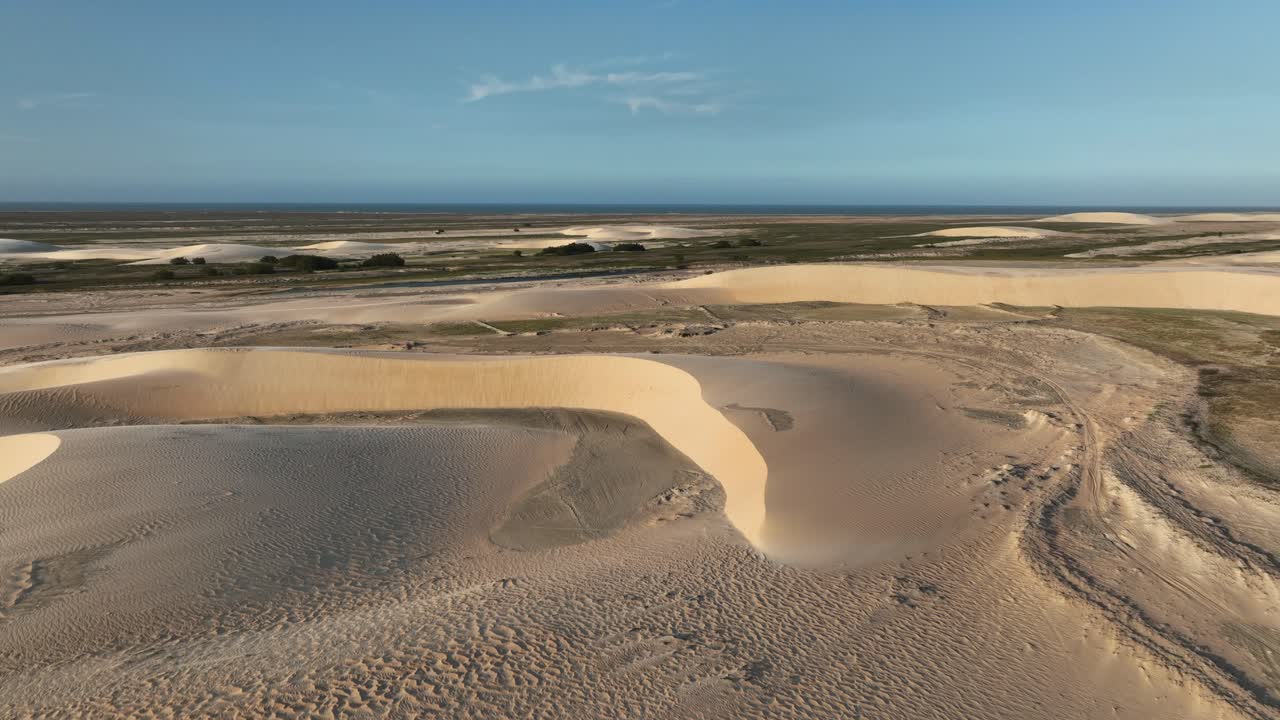 Vast sand dunes stretch endlessly under the bright sky at Lençóis Maranhenses National Park
