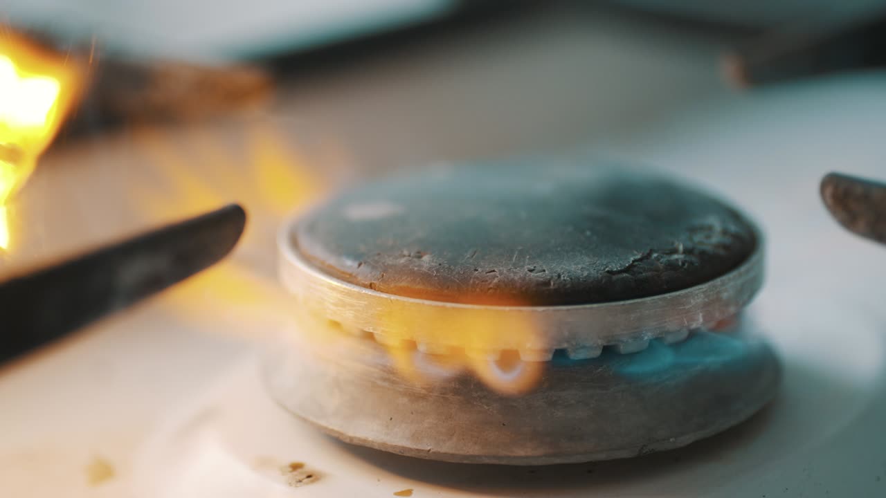 스토브 버너가 파란색 요리 불꽃으로 불타고 있습니다.