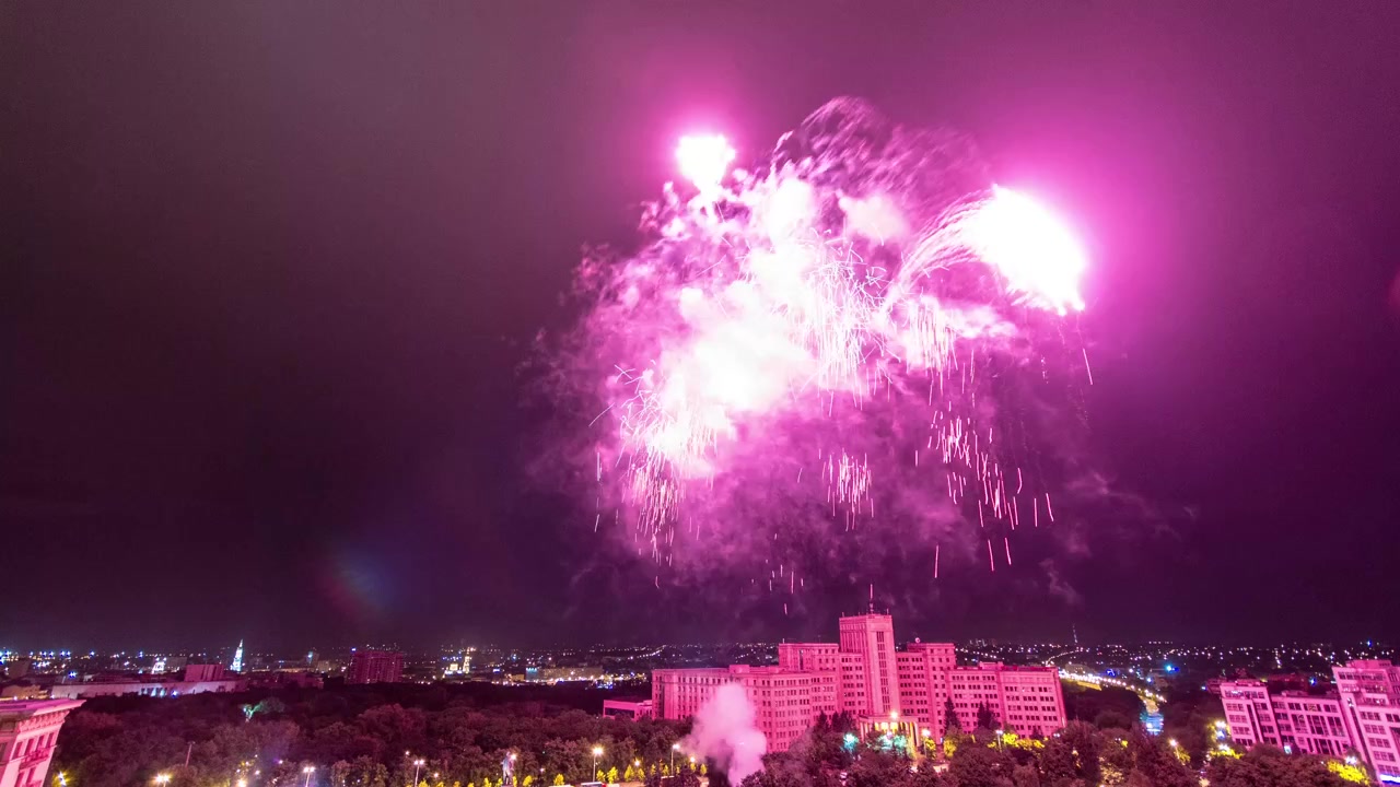 Kharkiv city from above at night timelapse. Aerial view of the city center and freedom square with fireworks. Ukraine