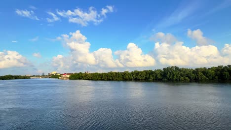 calm urban river flanked by green mangroves and city buildings under soft golden sky—perfect for nature, real estate, or city life themes