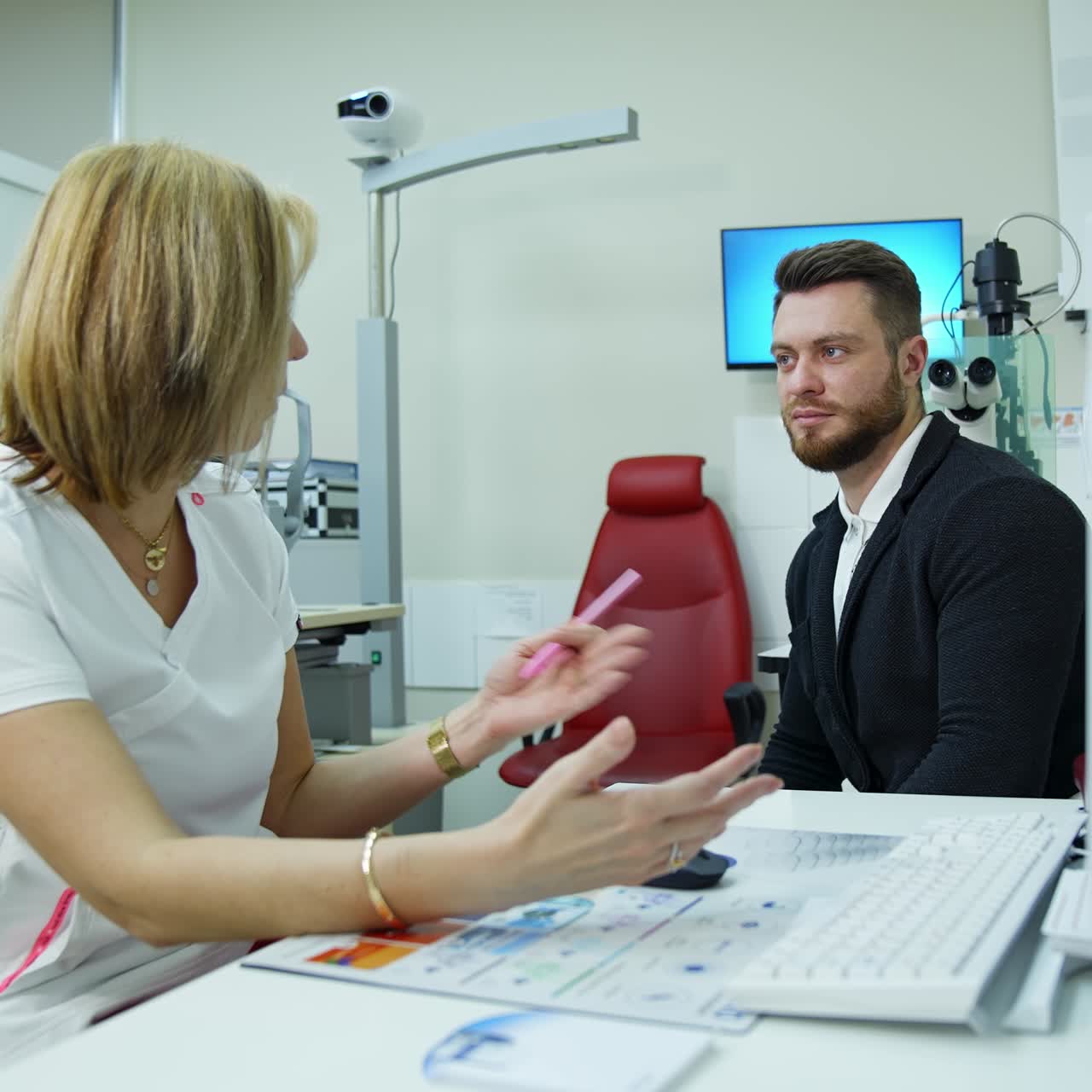 Ophthalmologist and a patient. Doctor consulting a male patient in eyesight center. Handsome man listens to a specialist in clinic