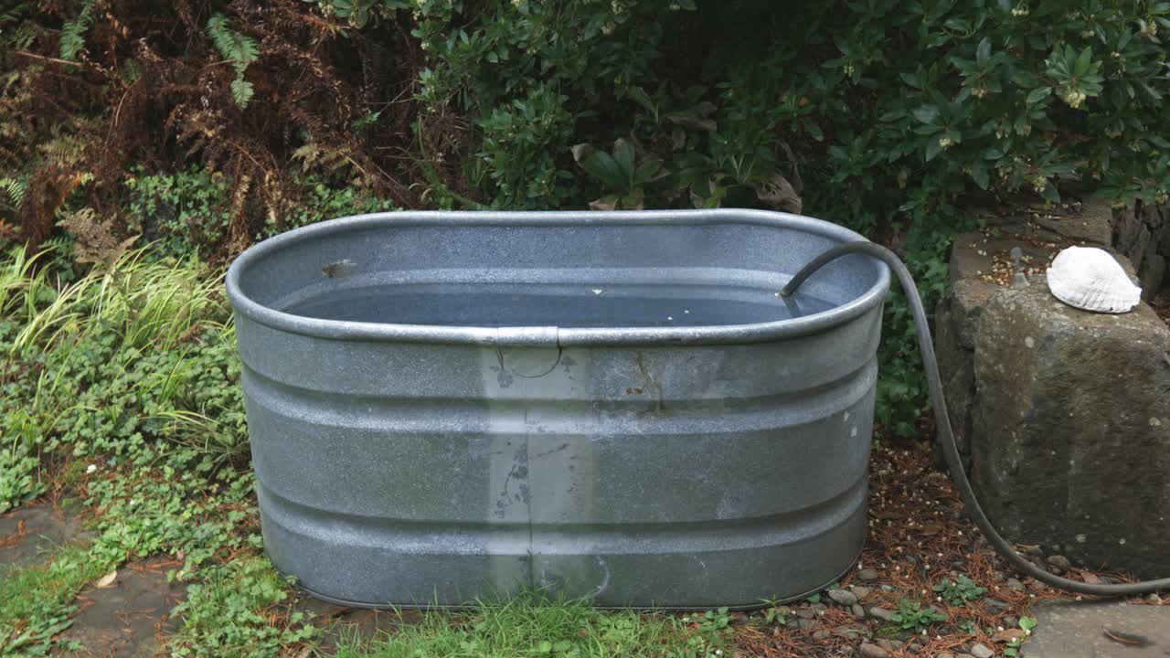 Cold plunge Galvanized Oval Tub being filled with a hose