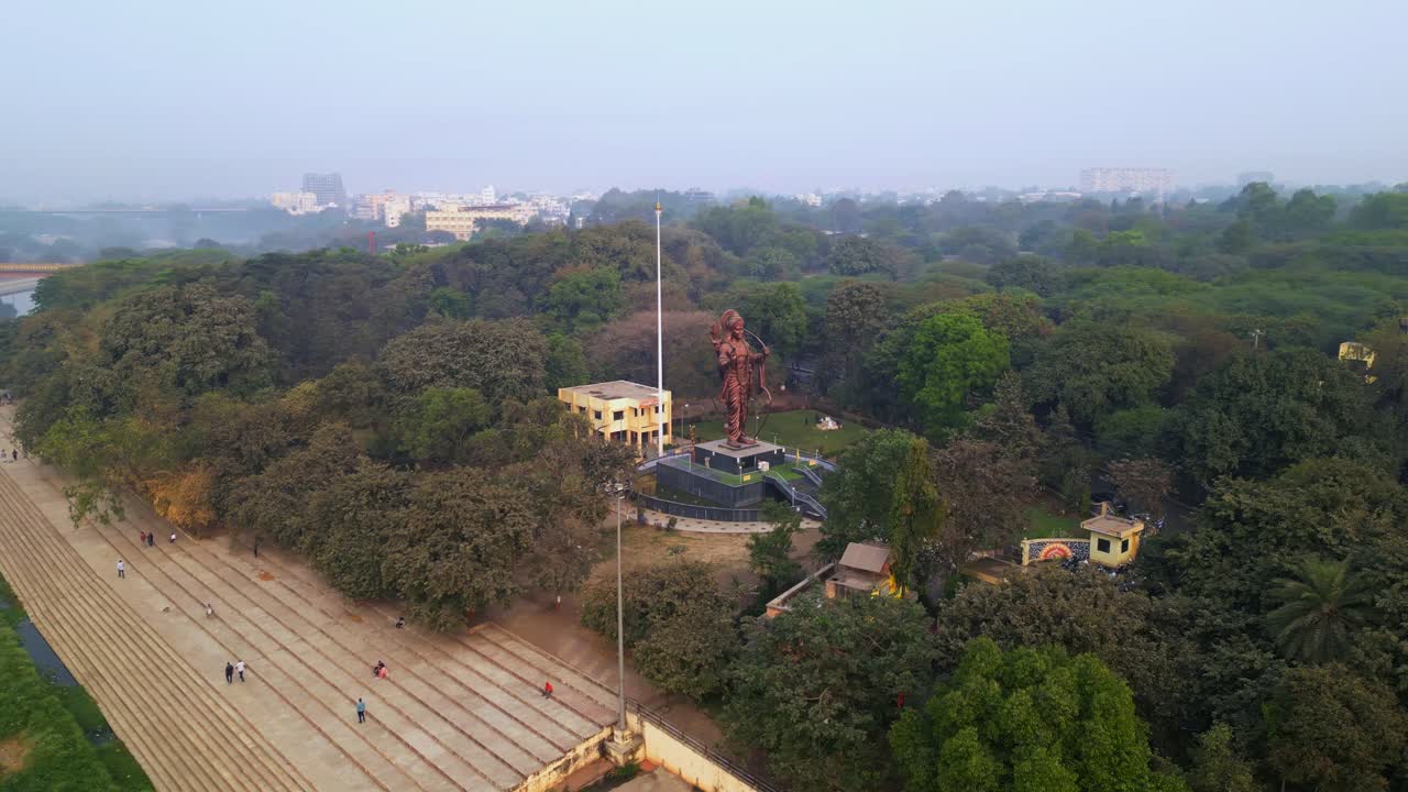Una vista aerea mozzafiato cattura l'idolo del Signore Rama di 70 piedi a Tapovan in Panchavati, Nashik, che si erge maestosamente accanto al sereno fiume Godavari, circondato da una vegetazione lussureggiante e un paesaggio sacro.