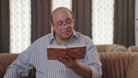 Happy-Indian-old-man-reading-a-book