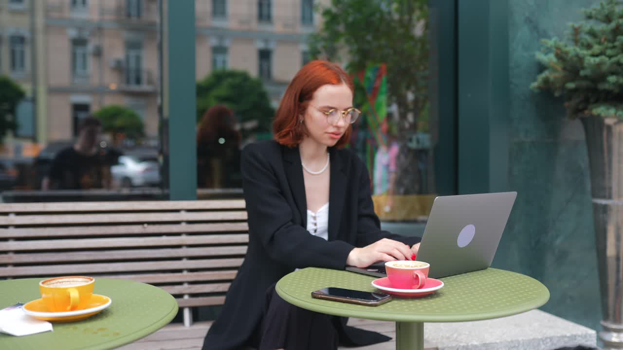 Kvinna som arbetar på en bärbar dator på ett café