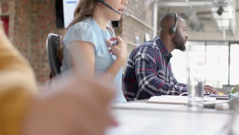 Portrait-of-happy-african-american-businessman-talking-on-phone-headset-at-office