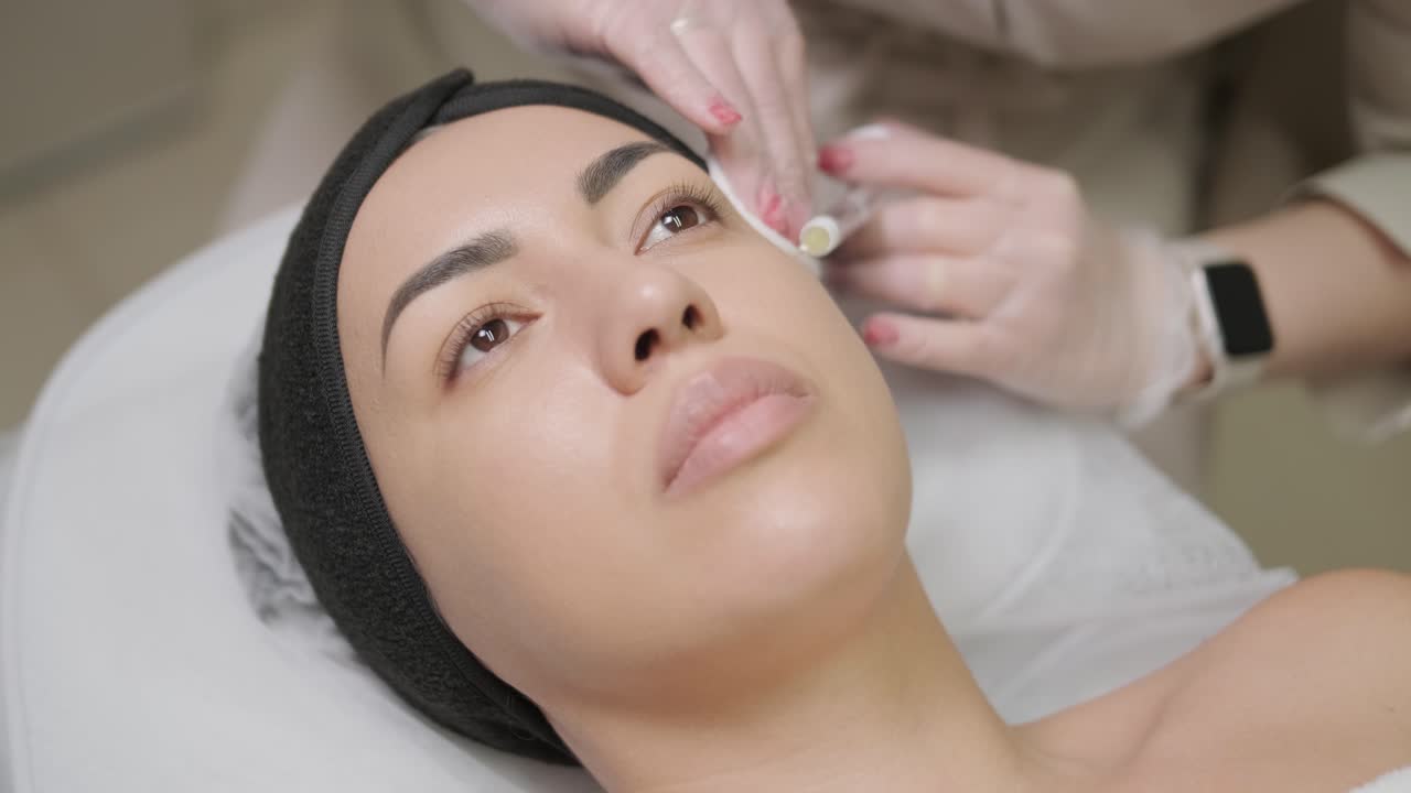 Woman making botulinum therapy in modern cosmetology clinic close up. Professional cosmetologist doing injection with botulinum toxin for rejuvenation face skin. Attractive lady patient smoothing wrinkles.