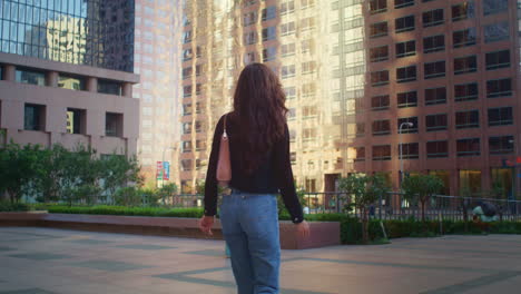 unknown stylish woman going street back view. brunette lady walking town avenue.