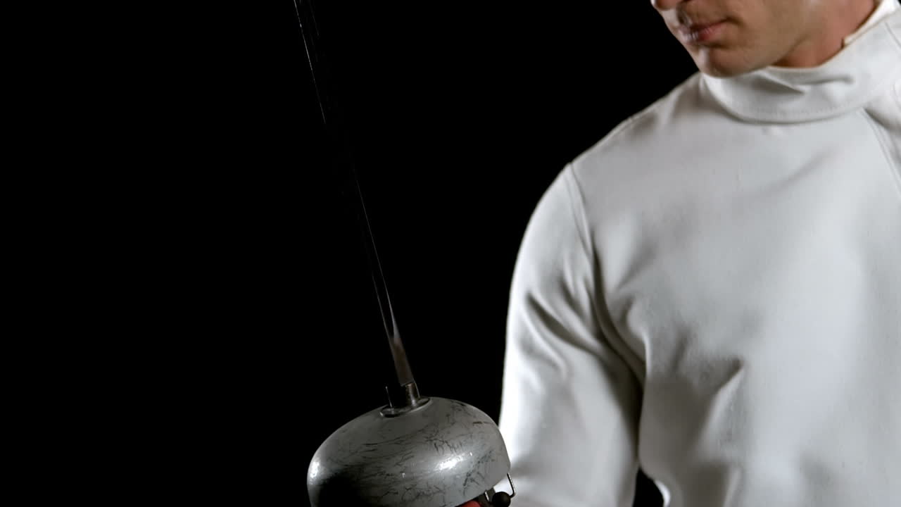 フェンシングプレーヤーが剣を見ている