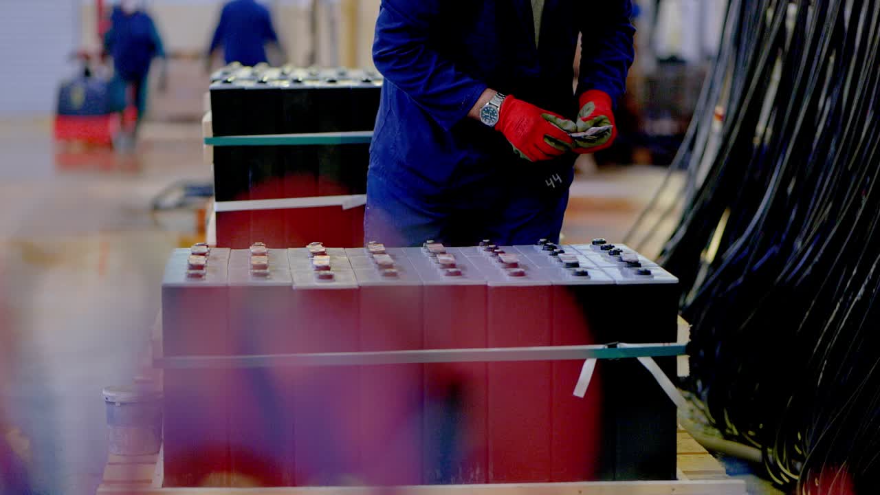 A person puts caps on batteries