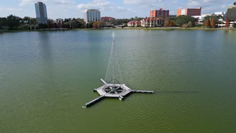 christmas tree adorned with lights in the center of lake morton in downtown lakeland florida during the holiday season