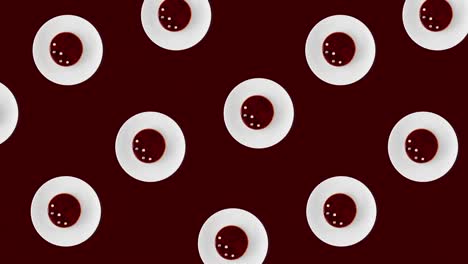 seamless animated pattern with many red round pastries with raspberry on a round plate above a vinous background, top view