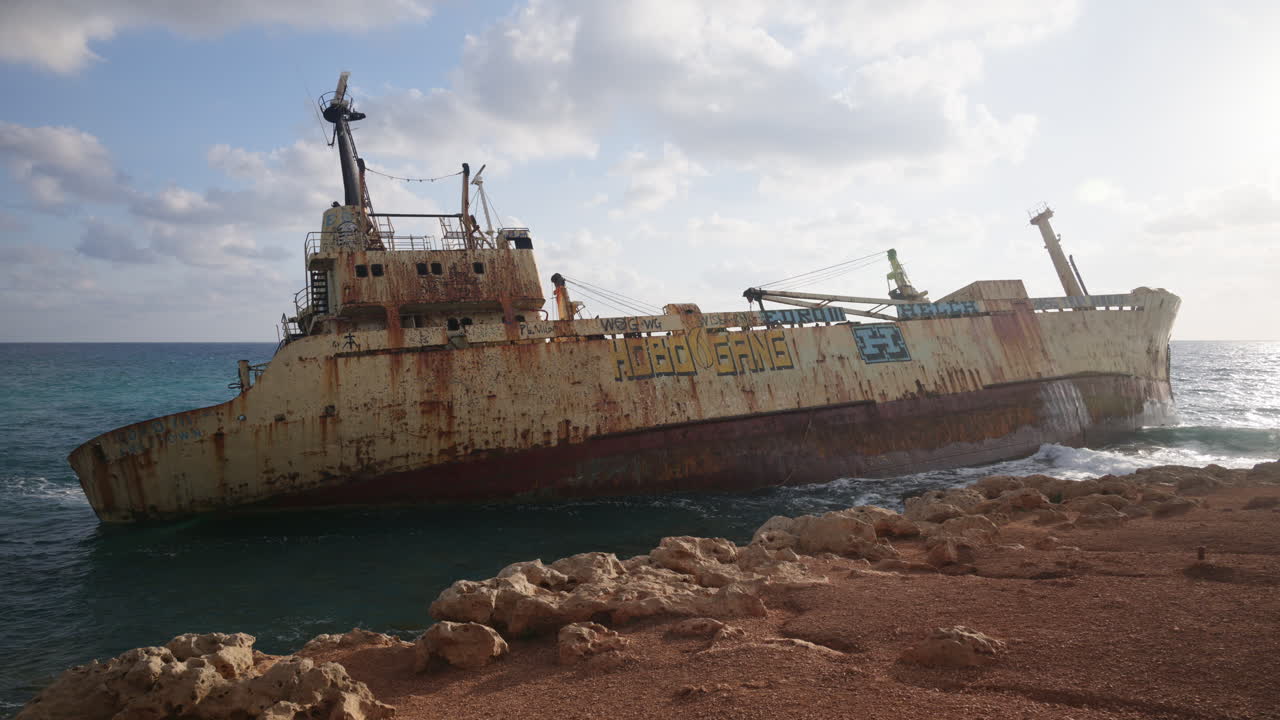 Pegeia, Chipre - 26 de fevereiro de 2026: Vista lateral do naufrágio abandonado Edro III a repousar em costas rochosas perto de Pafos, com texturas de ferrugem visíveis e detalhes de graffiti.