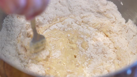 mixing flour into the wet ingredients to make dough - slow motion stirring with a fork