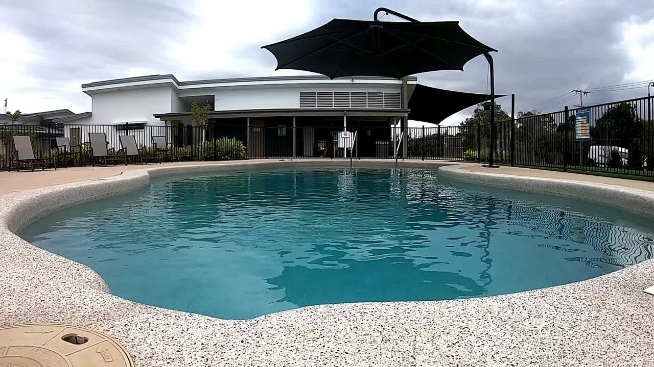 Mand går langs kanten af en swimmingpool