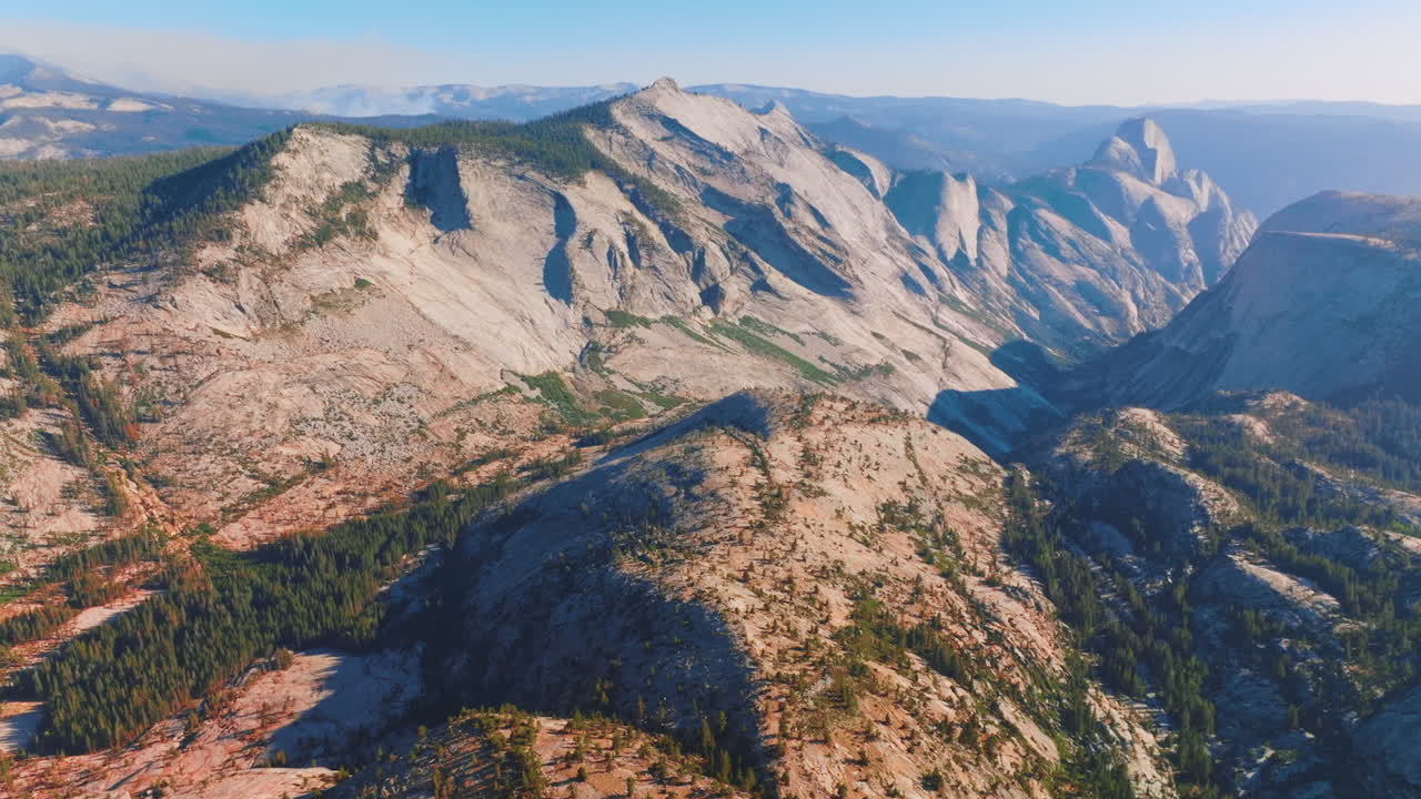 Grey rocks lit with bright sun. Mountainous landscape of Yosemite National Park, California, USA from bird's eye perspective.