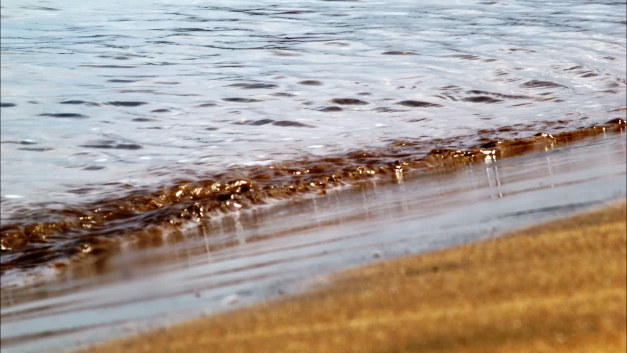 Onde Delicate Che Lambiscono la Riva di una Spiaggia Sabbiosa