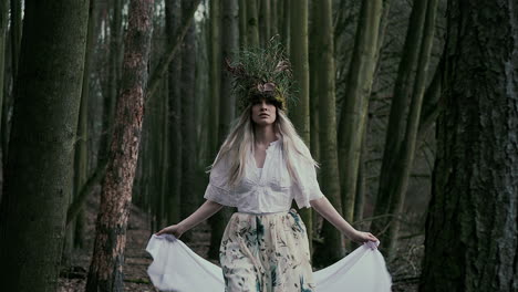 Beautiful-natural-fairy-with-white-veil-walking-in-forest,-front-dolly-shot